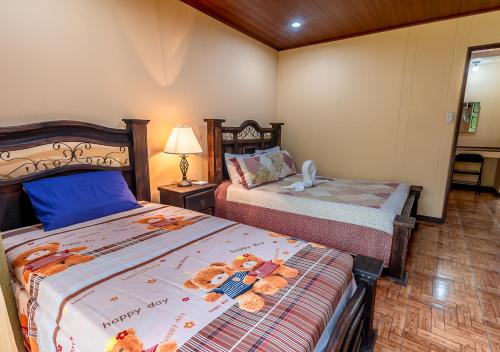 a bedroom with two beds with teddy bears on it at Aunty Arenal Lodge in Fortuna