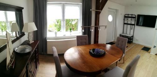 uma sala de jantar com uma mesa de madeira e cadeiras em Ferienhaus Schleeff em Elsfleth