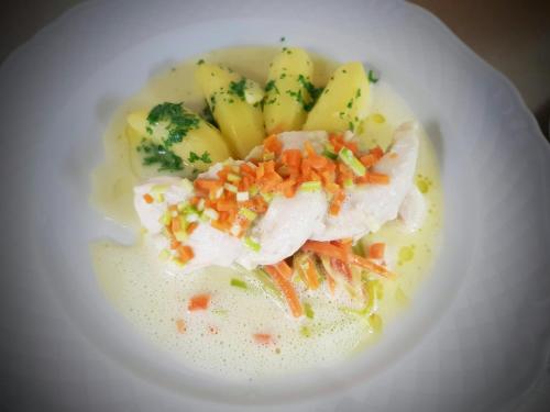 a white bowl of food with fruit and vegetables at Hotel zur Waage in Bad Münstereifel