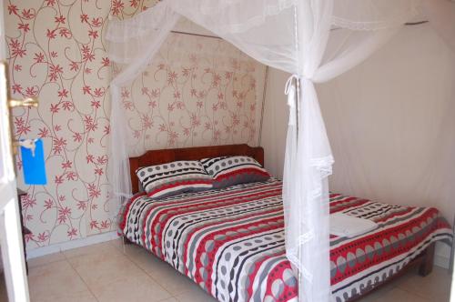 a bedroom with a bed with a canopy at Kigezi Gardens Inn in Kabale
