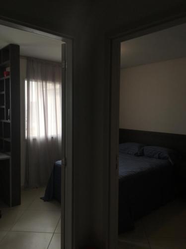 1 dormitorio con cama y puerta con espejo en Apartamento do Lago - São Paulo, en São Paulo