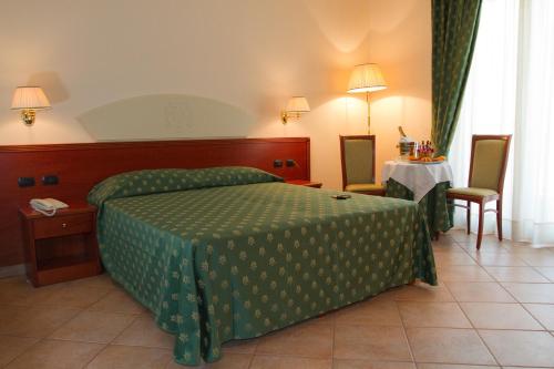 a hotel room with a bed and a table and chairs at Hotel Tito Serrano' in Melito di Porto Salvo