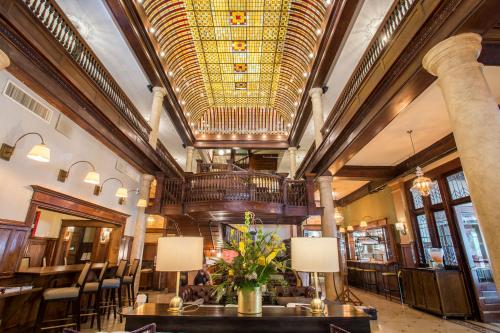 a lobby with tables and chairs and a large ceiling at Hotel Boulderado in Boulder