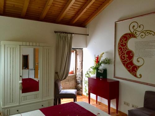 a bedroom with a bed and a chair and a mirror at Casa Lia da Pôrta in Caminha