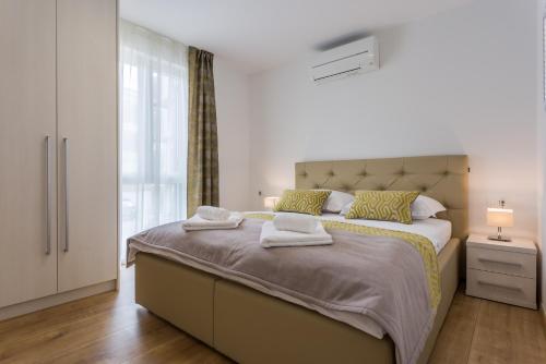 sypialnia z dużym łóżkiem z ręcznikami w obiekcie Pure Relax w mieście Malinska