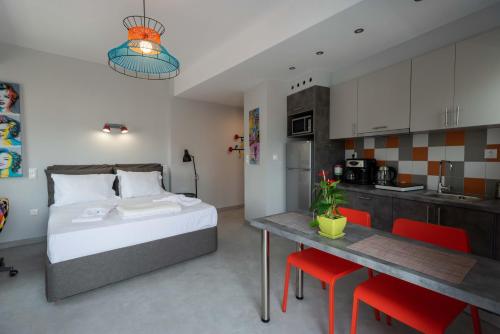 a bedroom with a bed and a table and a kitchen at Acropolis Monastiraki Newly Renovated Apartment in Athens