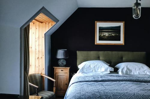 a bedroom with black walls and a bed with white pillows at Mackay's Rooms in Durness