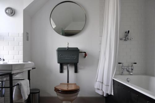 a bathroom with a toilet and a sink and a mirror at Mackay's Rooms in Durness