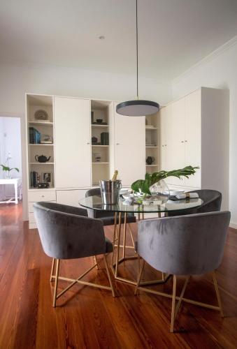 a dining room with a glass table and chairs at Quinta do Jasmim in Ponta Delgada