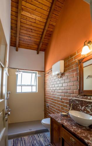 a bathroom with a sink and a toilet and a window at Villa Artjeta in Kastrosikia