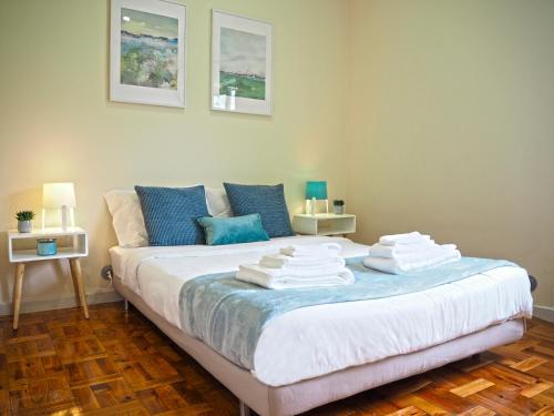 a bedroom with a bed with towels on it at Viana Lovers in Viana do Castelo