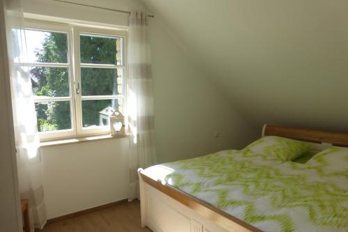 1 dormitorio con cama y ventana en Ferienwohnung am Eifelsteig, en Roetgen