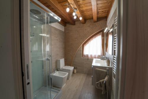 Fossalta di PortogruaroにあるB&B la Serenissimaのトイレとガラスのシャワー付きのバスルーム