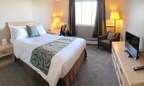 Habitación de hotel con cama y TV en Seasons Inn Halifax en Halifax