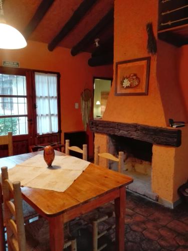 a dining room with a table and a fireplace at Establecimiento Rural El Chañar in San Rafael