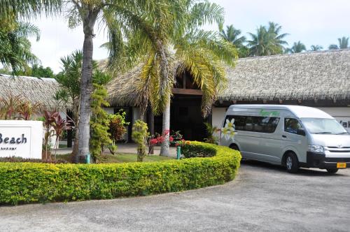 a van parked in a parking lot in front of a building at Tamanu Beach in Arutanga
