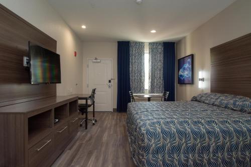 a hotel room with a bed and a desk at Palace Inn El Paso in El Paso