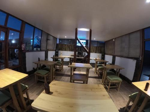 an empty restaurant with wooden tables and chairs at Hotel Casa Algarrobo in San Pedro de Atacama