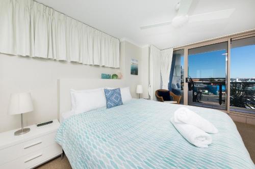 a bedroom with a bed and a window at Beaches International in Forster