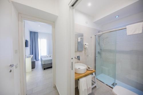 a bathroom with a shower and a toilet and a sink at Ossuna Bay Hotel Boutique in Cefalù
