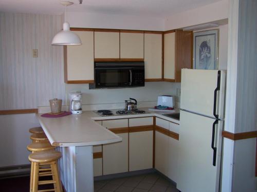 a kitchen with a refrigerator, stove, microwave and sink at Sea Drift Motel in Old Orchard Beach