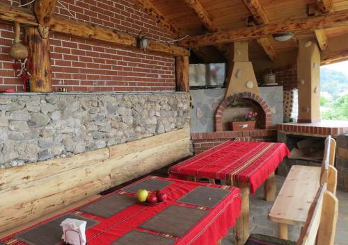 a room with two tables and a stone wall at Eco Village Under the Cliffs in Ilindentsi