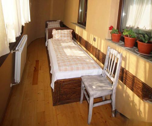 two beds in a room with a chair and a window at Eco Village Under the Cliffs in Ilindentsi