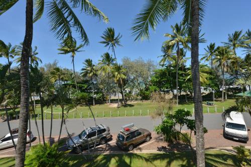 a parking lot with cars and palm trees at Seascape Holidays at Beachfront Terraces in Port Douglas