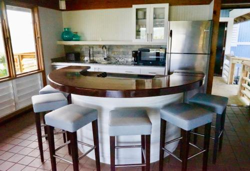a kitchen with a bar with stools and a refrigerator at Oceania Villas in Culebra