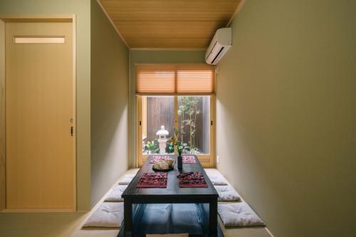 um pequeno quarto com uma mesa e uma janela em Miro Kujo Kawaramachi Tei em Quioto