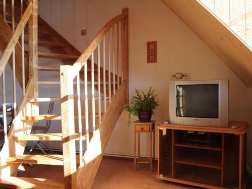a living room with a television and a staircase at Rodinny penzion Kunc in Slavonice