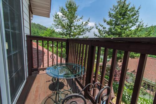 a balcony with a glass table and chairs on it at Sunny House in Pyeongchang 