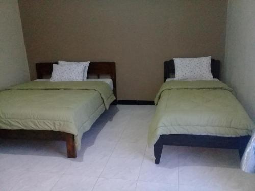 two beds sitting next to each other in a room at Cinnamon Guest House in Bajawa