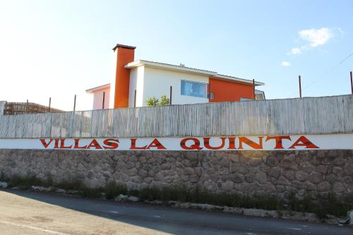 una valla con un cartel que lee villas la oulum en Villas La Quinta, en Creel
