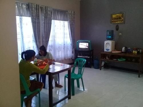 two women sitting at a table in a living room at Cinnamon Guest House in Bajawa