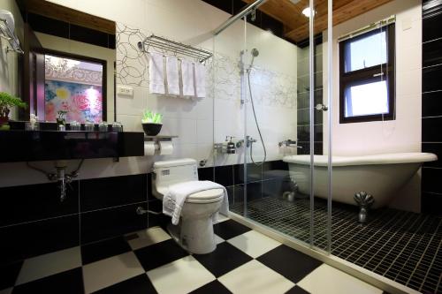a bathroom with a toilet and a shower and a tub at Sweet Heart B&B in Jian