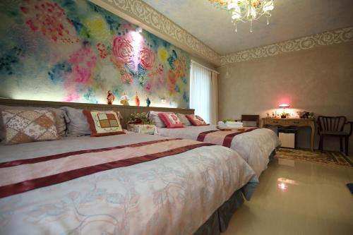 a bedroom with two beds and a painting on the wall at Sweet Heart B&B in Jian