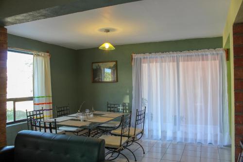 a dining room with a table and chairs and a window at Villas La Quinta in Creel