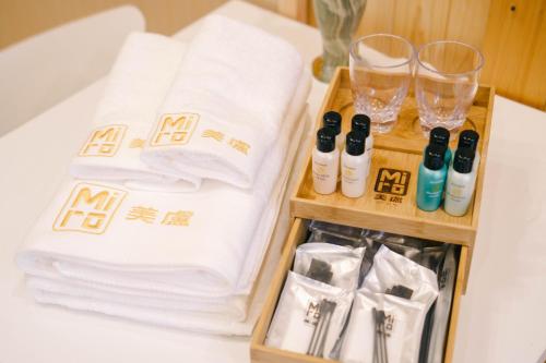 京都的住宿－米羅撒恩尼斯艾瑪達克特日式旅館，一张桌子,配有毛巾和酒杯及瓶子