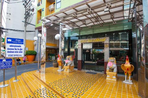 a building with statues of chickens in front of it at The Aiyapura Bangkok in Bangkok