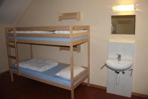 two bunk beds in a bathroom with a sink at Bern Backpackers Hotel Glocke in Bern
