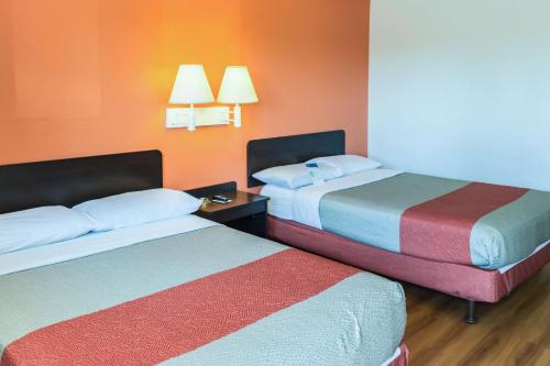 two beds in a room with orange walls at Motel 6-Bakersfield, CA - East in Bakersfield