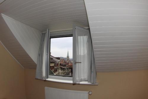 a window in a room with a view of a city at Bern Backpackers Hotel Glocke in Bern