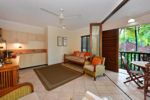 a kitchen and living room with a couch and a table at Seascape Holidays - Hibiscus in Port Douglas