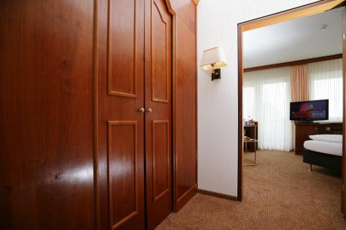 a room with a door and a mirror and a bedroom at Badhotel Restaurant Stauferland in Bad Boll