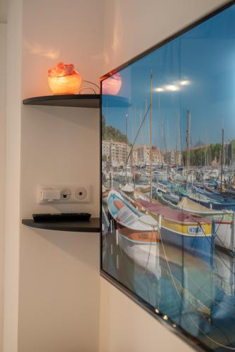 une télévision accrochée au mur avec une photo de bateaux dans l'établissement 