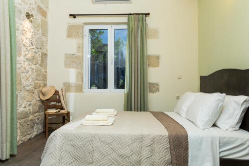 a bedroom with a large bed with a window at Margarita's Stone House in Plátanos