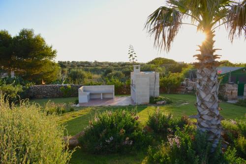a house with a palm tree in a garden at Tramonto A Nordovest in Favignana