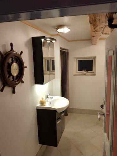 ein Bad mit einem Waschbecken und einem Spiegel in der Unterkunft Ferie På Toppen in Skagen