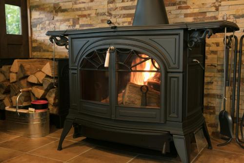 a stove with a fire in a room at Okushiga Lodge Yama no Manimani in Yamanouchi